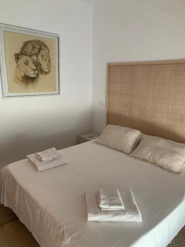 Un dormitorio con una cama blanca con una foto en la pared en Apartamento con terraza y acceso directo a piscina, en Denia