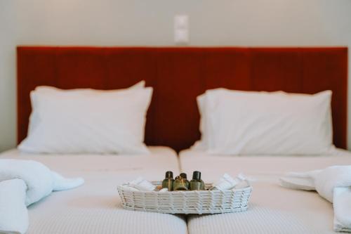 a basket of perfume bottles sitting on a bed at Karavostasi Beach Hotel in Perdika