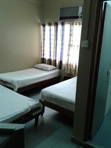 a room with two beds and a window at HotelMalaya in Taiping