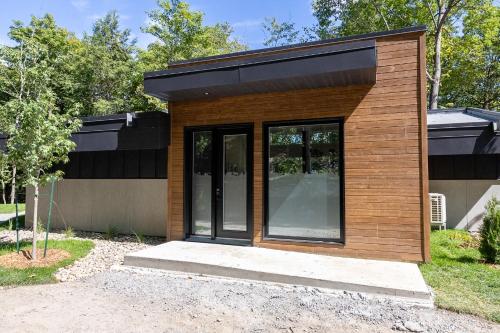 a small house with a black roof at Parc Omega in Montebello