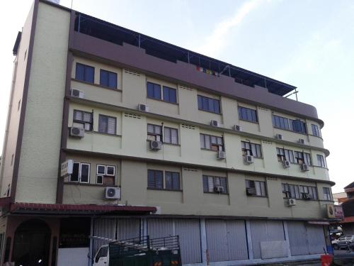 a large white building with windows on a street at HotelMalaya in Taiping