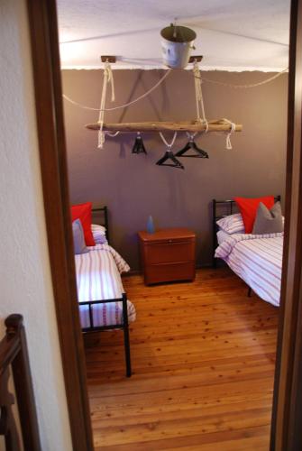 Habitación con 2 camas individuales y suelo de madera. en Cà Mia en Nus