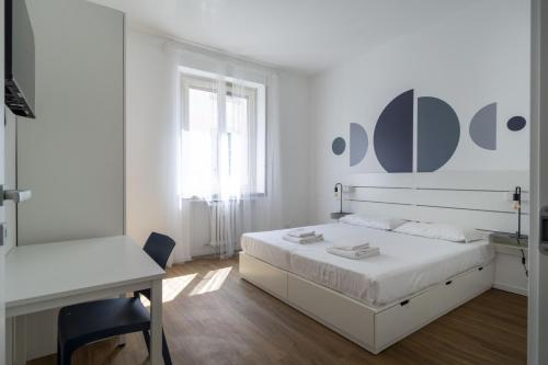 a white bedroom with a bed and a desk at Easylife - Esperienza unica nel cuore di Moscova in Milan