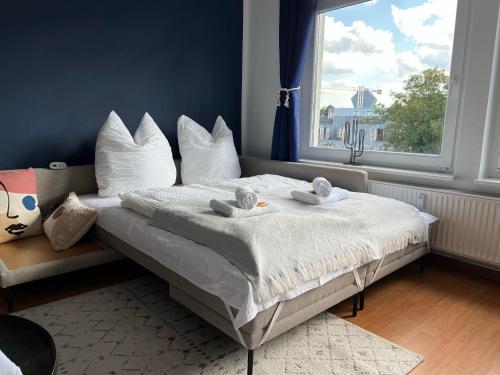 a bedroom with a bed with white pillows and a window at Große Wohnung im Zentrum von Osnabrück in Osnabrück