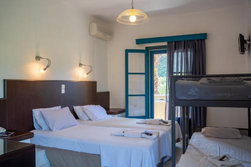 a bedroom with two beds and a bunk bed at Karavostasi Beach Hotel in Perdika