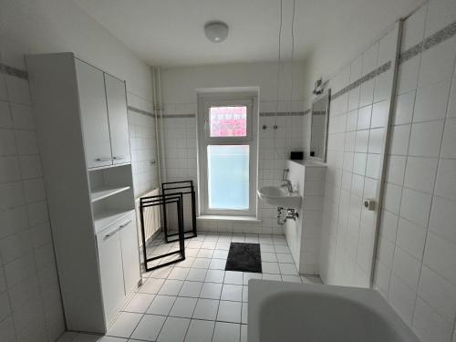 Baño blanco con bañera y lavamanos en Eastside 35 en Berlín
