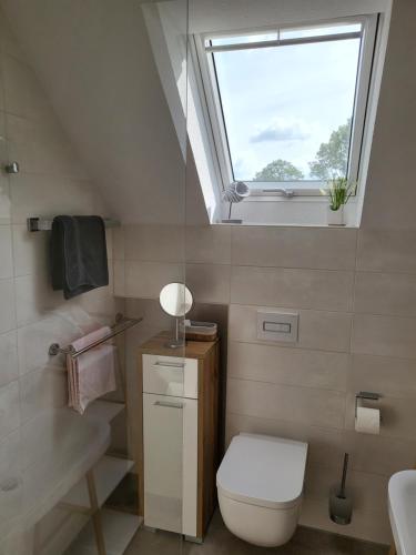 een badkamer met een toilet en een raam bij harle-casa.ostfriesland in Altfunnixsiel