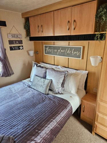 a bedroom with a bed with a wooden headboard at Rhuddlan Salty Smiles in Rhuddlan