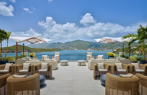 a patio with chairs and tables and a view of the ocean at The Westin St Thomas Beach Resort & Spa in Frydendal
