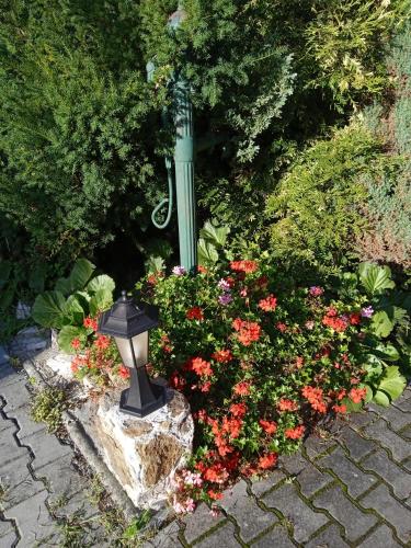 a garden with a statue in the middle of flowers at Penzion Kalina in Tábor