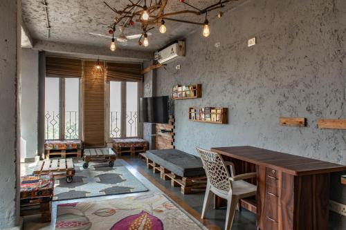 - un salon avec une table et des chaises en bois dans l'établissement JHouse near Bhikaji, à New Delhi