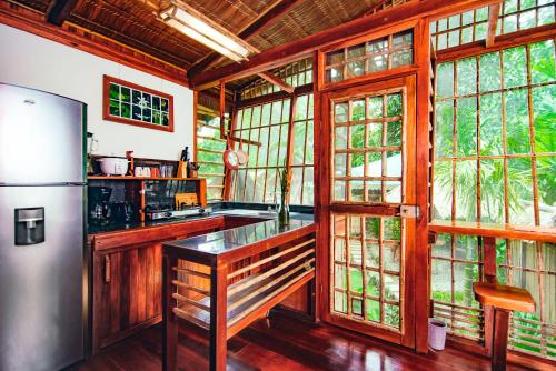 cocina con paredes y ventanas de madera y nevera en Villa # 2 - Luxury 1 Bed Villa - Private Garden, en Cocles
