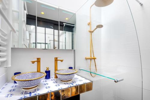a bathroom with two bowls on a counter at Hameau du Château de Giverzac, gîtes luxueuses in Domme