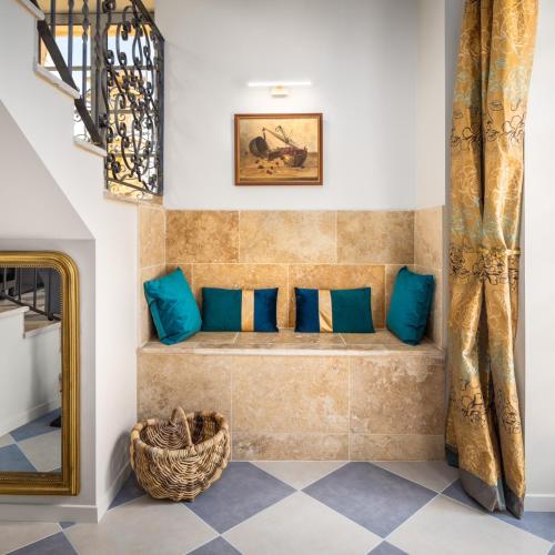 a room with a bench with blue pillows at Hameau du Château de Giverzac, gîtes luxueuses in Domme