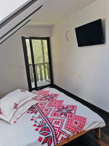 a bedroom with a bed with a quilt on it at Cabana Briana in Valea Drăganului