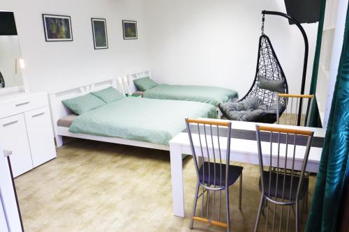 a bedroom with a bed and a table and chairs at STUDIO STUDIO + in Vrbas