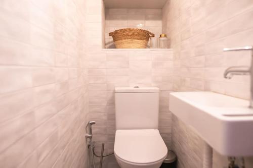 Un baño blanco con inodoro y lavabo. en Olvia A breath away from Old Town Center, en Rethymno