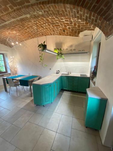 una cucina con armadi verdi e una sala da pranzo di La Dimora delle Viole a Lauriano