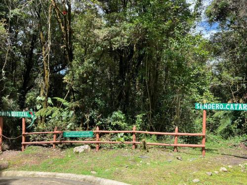聖何塞的住宿－Cabaña Anturios，树前有路标的木栅栏