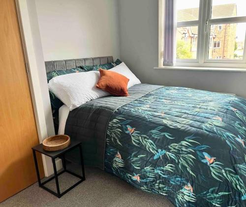 um quarto com uma cama com um cobertor tropical temático em The Gainsborough Mews-stylish & modern (sleeps 3) em Lincolnshire