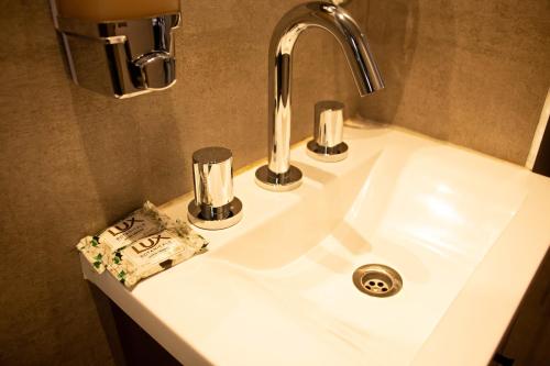 La salle de bains est pourvue d'un lavabo et d'un robinet. dans l'établissement 9 DE JULIO Y OROÑO ROSARIO, à Rosario