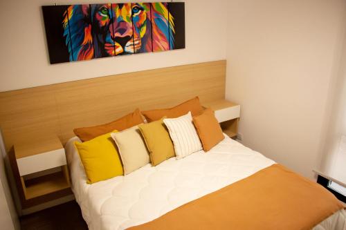 a bedroom with a bed with yellow and white pillows at 9 DE JULIO Y OROÑO ROSARIO in Rosario