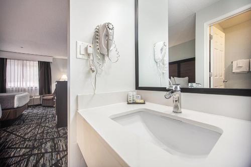 a bathroom with a large white sink and a mirror at Baymont by Wyndham Grand Haven in Grand Haven