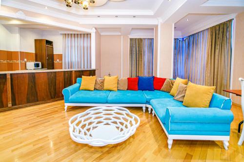 a living room with a blue couch and a coffee table at Deluxe Apartment 142/43 in Baku