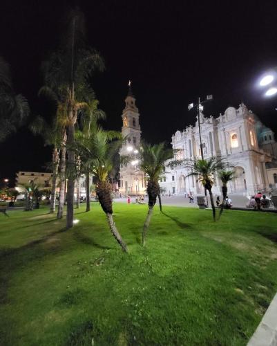 a building with palm trees in a park at night at ArcHome in Pompei