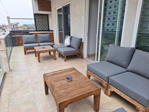 a patio with couches and a coffee table on a balcony at Rosarito Beach condominio in Rosarito