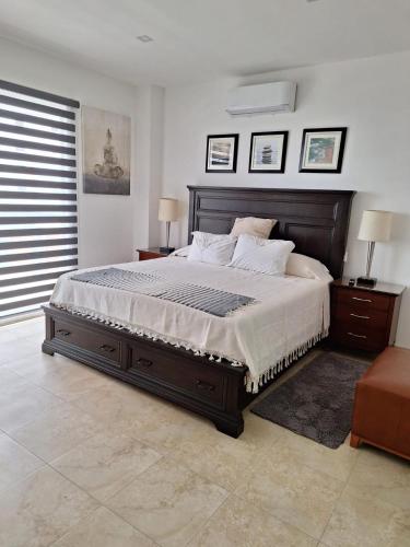 a bedroom with a large bed and two night stands at Rosarito Beach condominio in Rosarito