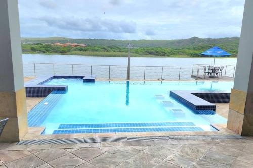 a large swimming pool with a view of the water at Modern 2Bedroom Self Catering unit HBos. in Mossel Bay