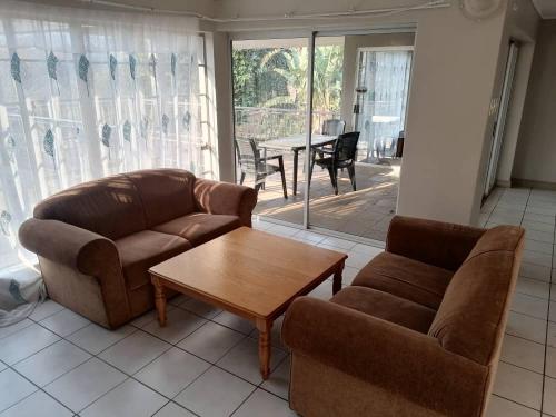 a living room with a couch and a coffee table at Redberry Guest House in Mbabane