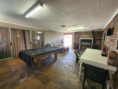 a living room with a ping pong table in it at Midway Overnight Rooms in Kimberley