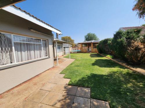 a house with a lawn next to a house at Midway Overnight Rooms in Kimberley