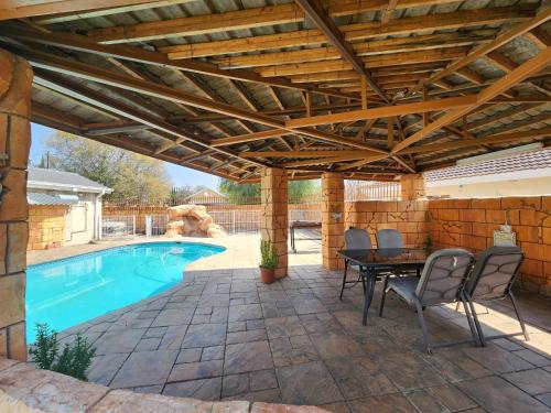 a patio with a pool and a wooden pergola at Midway Overnight Rooms in Kimberley