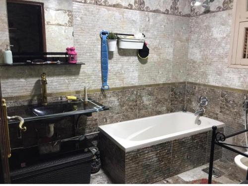 a bathroom with a sink and a bath tub at مصر الجديدة - ميدان اسماعيلية - comfortable private room with balcony - Masr el gedida in Cairo
