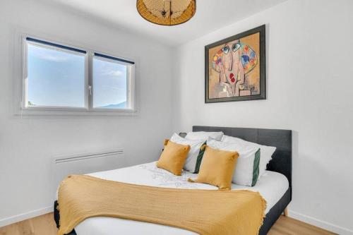 Dormitorio blanco con cama con almohadas amarillas en Les Pieds dans l'Eau, en Tresserves