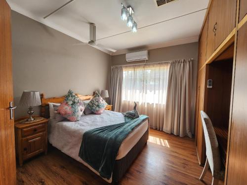 una camera da letto con un letto e un gatto seduto sopra di Midway Overnight Rooms a Kimberley