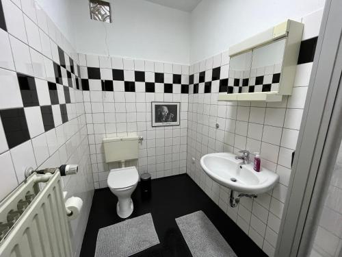 Baño en blanco y negro con aseo y lavamanos en Ruhe-Oase, en Herne