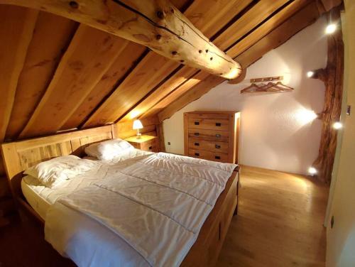 a bedroom with a large bed in an attic at Buckey Lodge, à 2 minutes des cascades de Tendon in Tendon