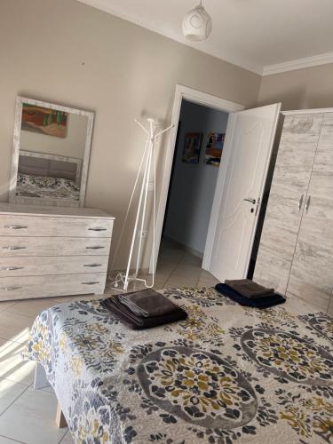 a bedroom with a bed and a dresser and a mirror at Lungomare Rei's Apartment in Durrës