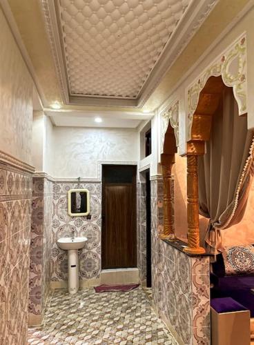 La salle de bains est pourvue d'un lavabo et d'une porte. dans l'établissement calm space near to valle, à Ourika