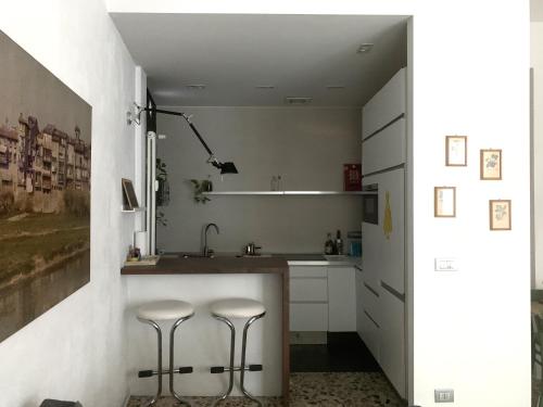 a kitchen with a sink and two stools at Il Giardino Segreto in Parma