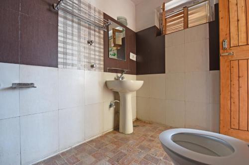 een badkamer met een wastafel en een toilet. bij Tourist Hotel 10 minutes walking distance from the mall in Manāli