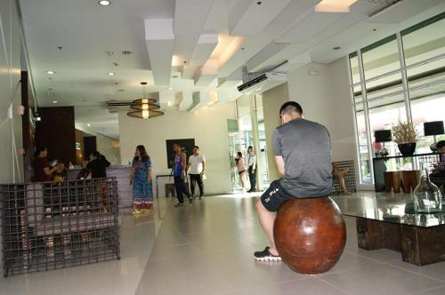 un hombre sentado en una gran bola en un edificio en The Beacon Makati by mvmtransient en Manila