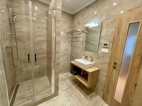 een badkamer met een douche, een wastafel en een glazen douchecabine bij Apartmány Lavender 