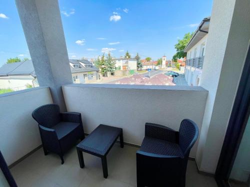 a balcony with chairs and a view of a street at Apartmány Lavender in Nova Dedinka