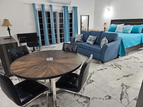 Roots Cafe Rooms في نيغريل: غرفة معيشة مع أريكة زرقاء وطاولة