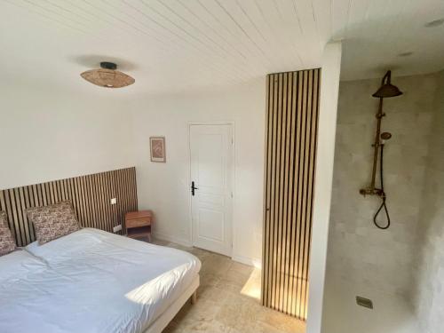 een slaapkamer met een bed en een deur naar een kamer bij Maison en Normandie - 5 min plage Houlgate - Villers sur mer in Auberville